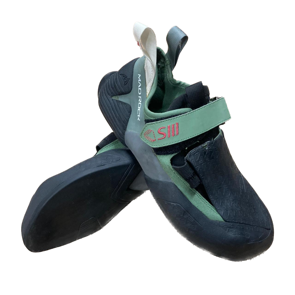 A pair of climbing shoes from the brand MADROCK, featuring a dark gray and mint green color scheme with a prominent green hook-and-loop strap on the side.